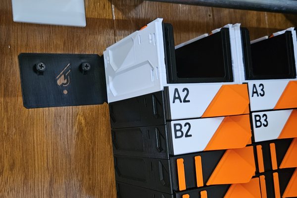 A Wall Mount Lite bracket screwed into a wood-panelled wall beside a stack of labeled drawers