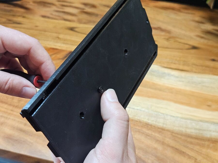 Pulling an M3 nut into an underside slot of the Size Adapter Cover with a screw