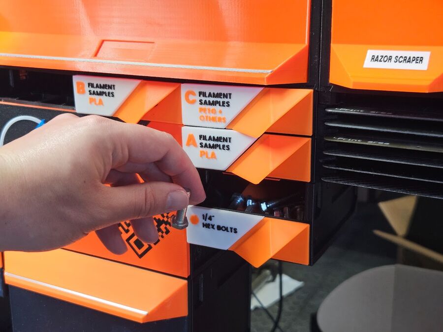 Open bin drawers in use on a build, labeled and filled with hardware