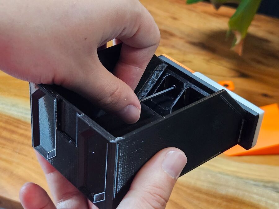 Driving the M3x6mm screw through the back of the bin with a hex wrench