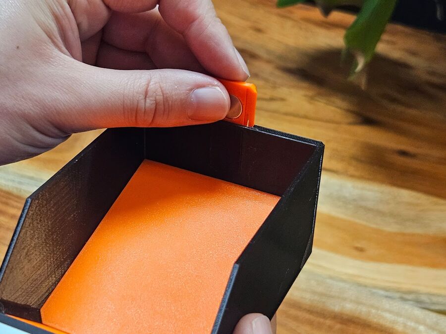 Pressing a magnet insert into its slot on the bin body