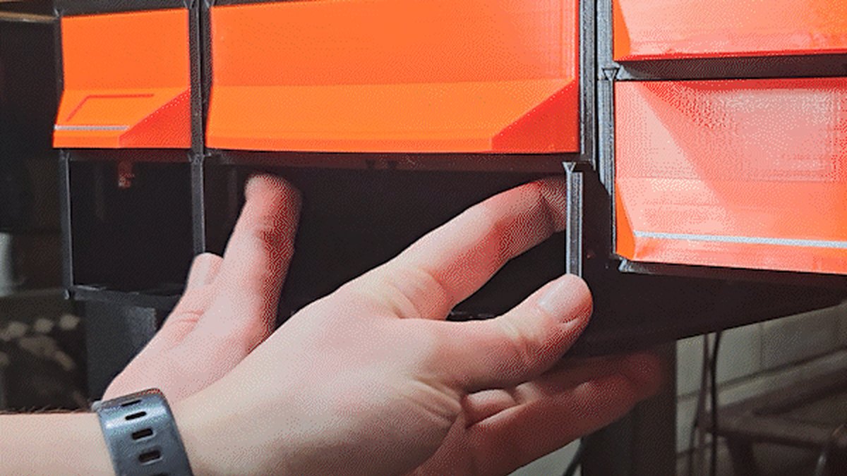 Video: under a table, two fingers reach inside an empty case, pull both QuickLocks down, and the case slides out toward the camera