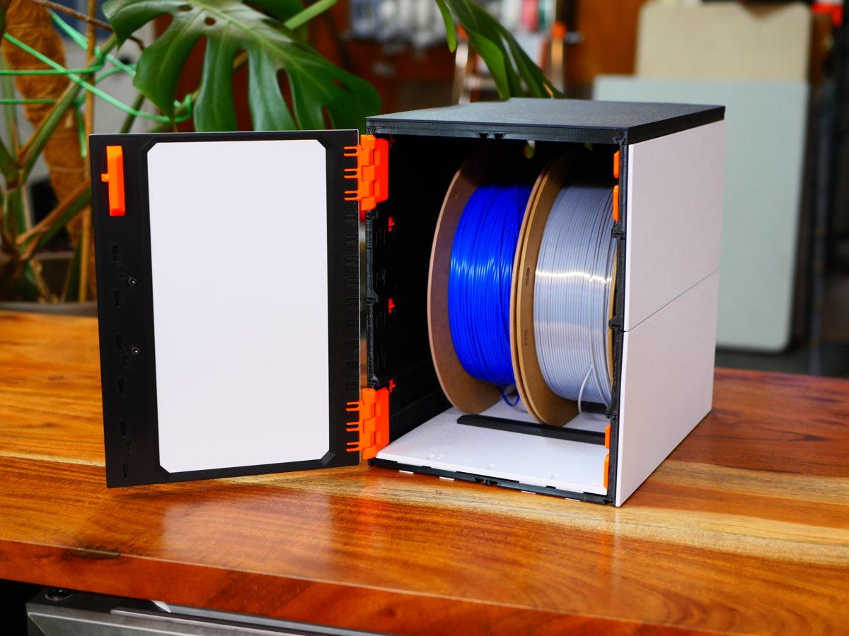 The cabinet open with two filament spools standing inside