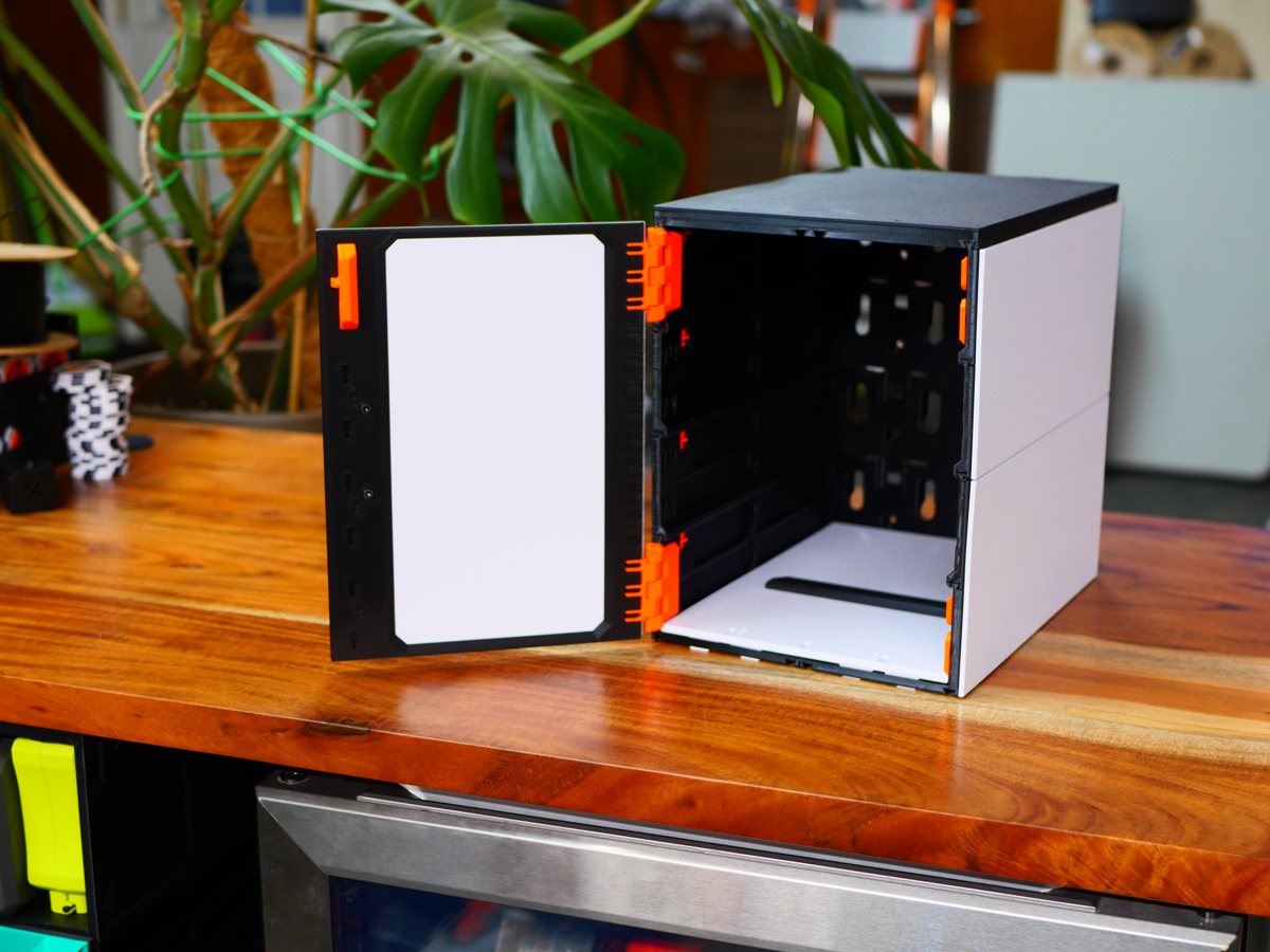 The same cabinet with its door swung open on orange hinges, an empty shelf bay inside