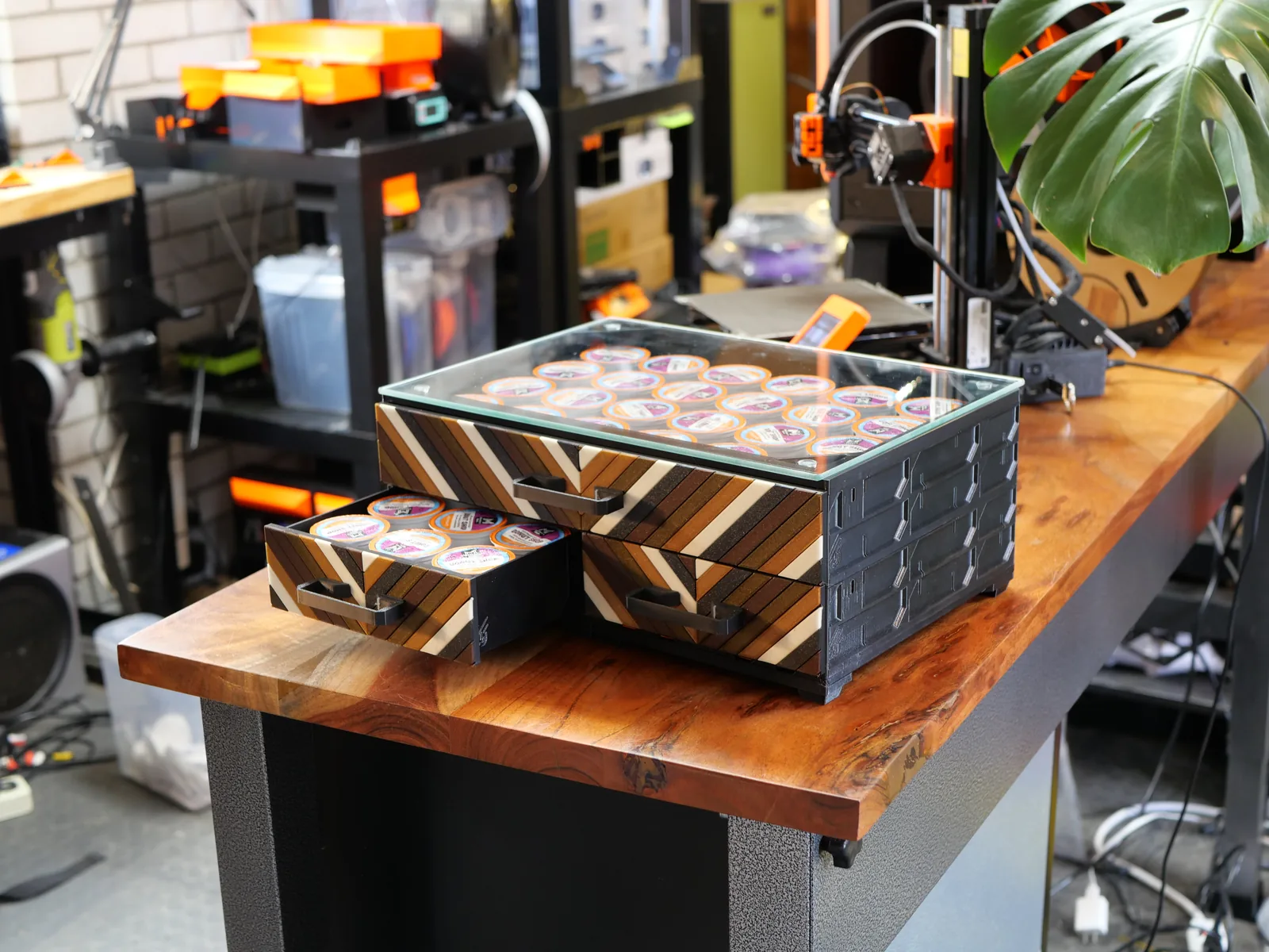 A coffee station: Chevron faceplates with every strip a different brown, cream or black, under a glass top of coffee pods