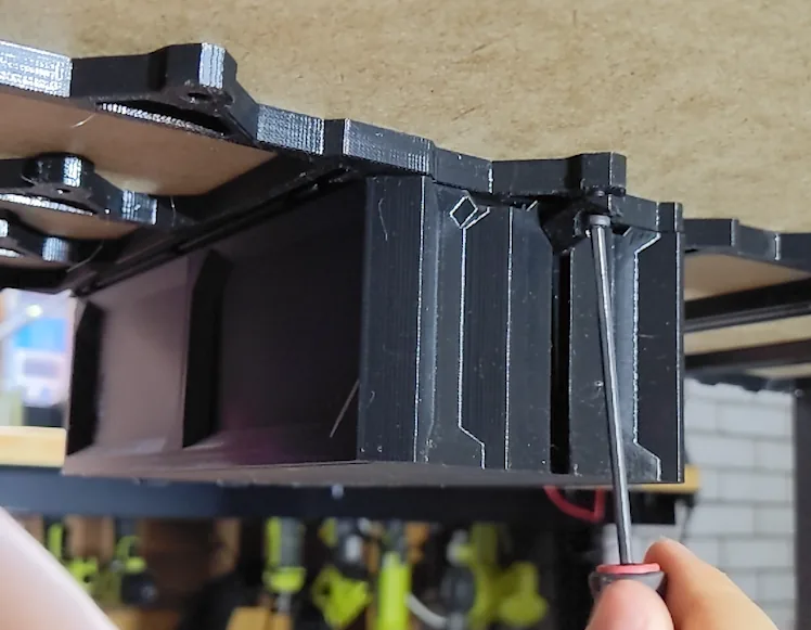 Securing a case to its rail with a screwdriver, from behind - the job QuickLock retired.